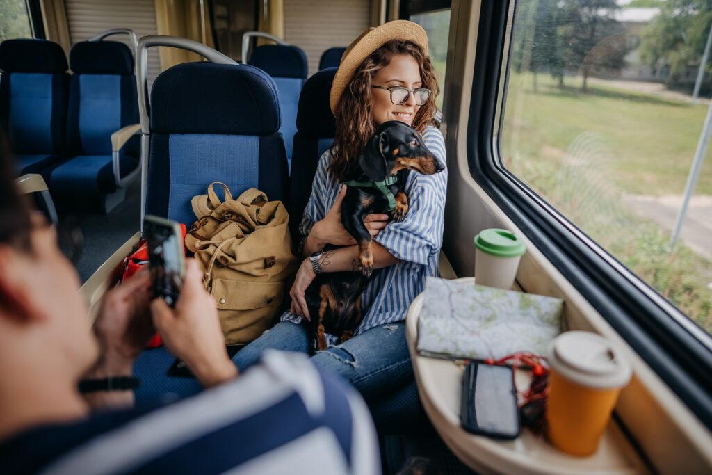Frau mit Dackel faehrt-Bahn